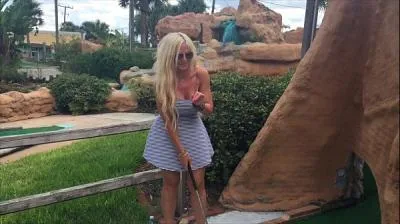 Горячая блондинка Келли Каббана играет в мини-гольф на публике